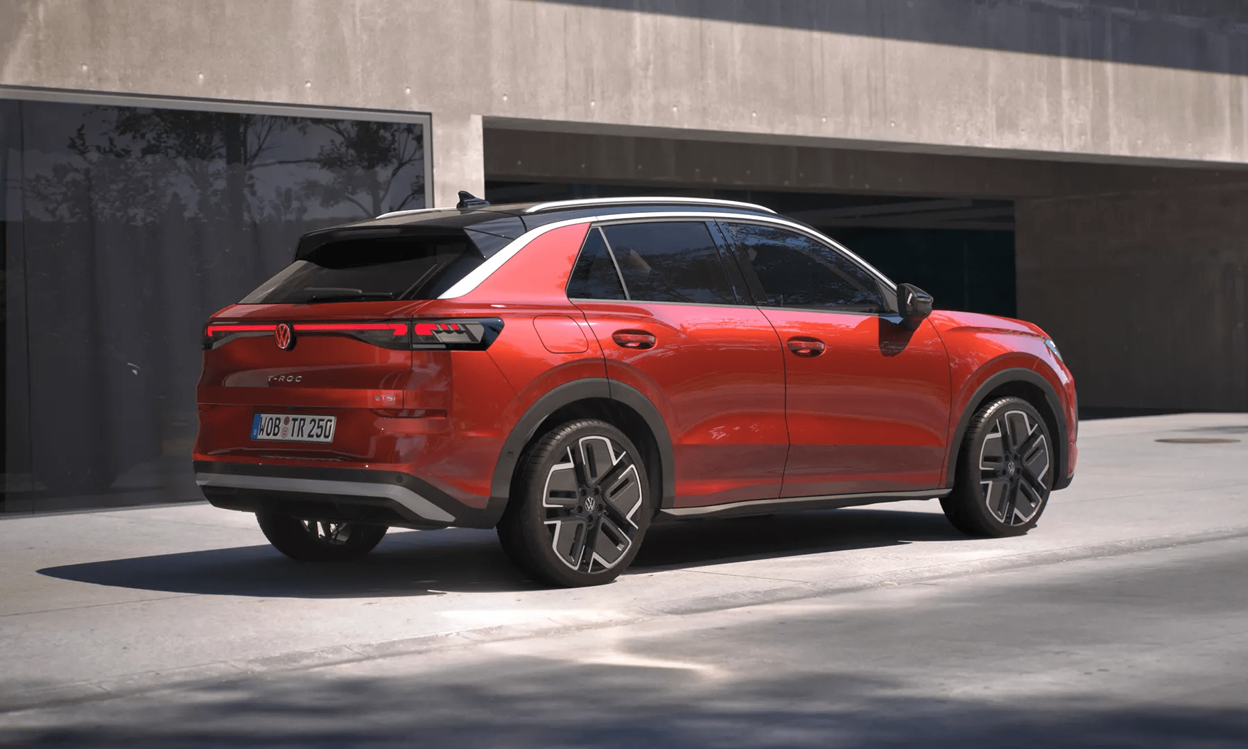 Sarkans Volkswagen T-Roc Style redzams no aizmugures uz ielas.